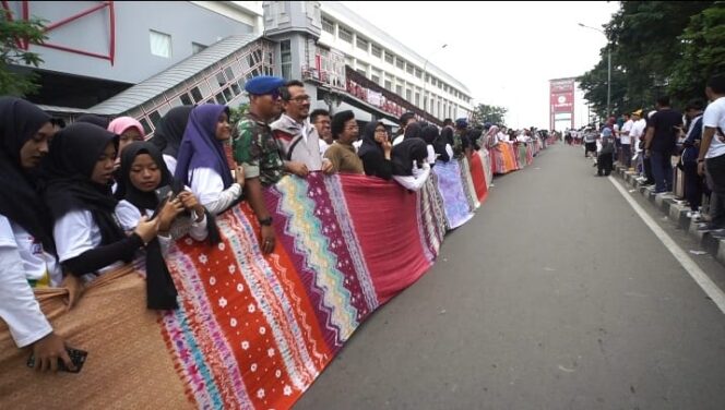 
					Jokowi Bentangkan Kain Jumputan 1,1 Kilometer di Jembatan Ampera