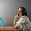 boring woman sitting with laptop and yawning