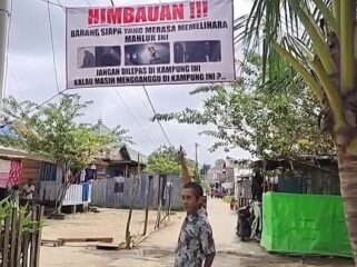 Warga saat menunjukkan baliho tuyul di Jakabaring. Foto : Istimewa
