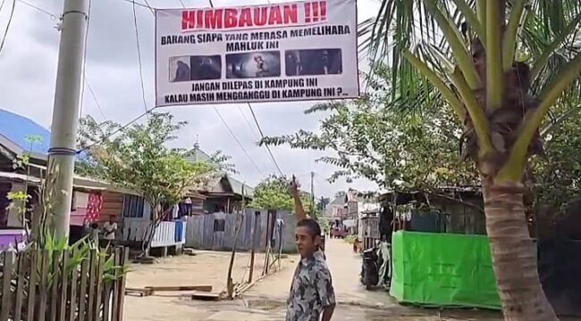 Warga saat menunjukkan baliho tuyul di Jakabaring. Foto : Istimewa