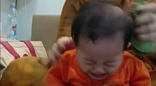 Dalam sebuah rekaman, Seorang perempuan yang dikenal sebagai Ibu Ika tampak melakukan terapi totok dengan menggunakan daun sirih kepada bayi yang terus menangis/ist. 