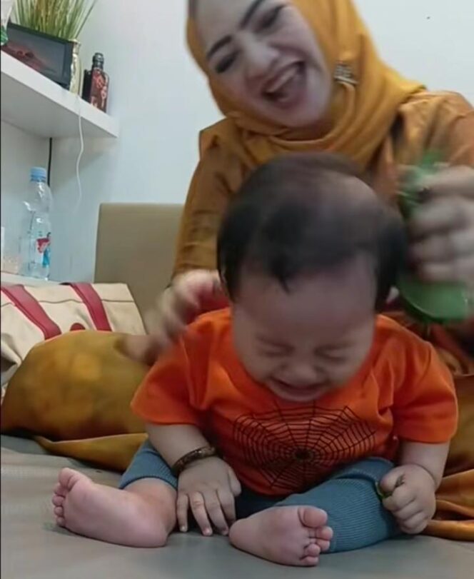 
Dalam sebuah rekaman, Seorang perempuan yang dikenal sebagai Ibu Ika tampak melakukan terapi totok dengan menggunakan daun sirih kepada bayi yang terus menangis/ist. 