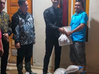 Camat Baturaja Timur Doni Heridadi menyalurkan bantuan dari Bupati OKU berupa bahan makanan beras dan paket sembako kepada masyarakat yang terdampak banjir akibat luapan Sungai Ogan. Foto : Ist