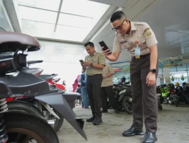 Kepala Bapenda Sumsel Ahmad Rizwan saat mengecek pajak kendaraan yang sedang parkir. Foto : Bapenda Sumsel