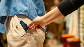 Close-up on a thief stealing a cell phone of a customer at a shopping store - pickpocketing concepts