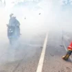 Pengendara motor yang menerobos kepulan asap yang berasal dari kebakaran lahan dan hutan di jalur lintas Sumatera, Ogan Ilir, Sumsel, Minggu (3/9) Foto: ary priyanto/urban id