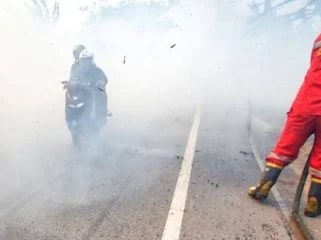 Pengendara motor yang menerobos kepulan asap yang berasal dari kebakaran lahan dan hutan di jalur lintas Sumatera, Ogan Ilir, Sumsel, Minggu (3/9) Foto: ary priyanto/urban id