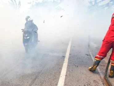 Pengendara motor yang menerobos kepulan asap yang berasal dari kebakaran lahan dan hutan di jalur lintas Sumatera, Ogan Ilir, Sumsel, Minggu (3/9) Foto: ary priyanto/urban id